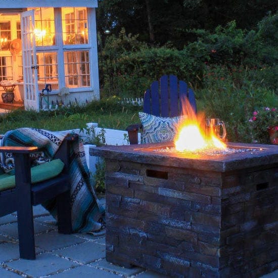 Cheminée au bio-ethanol cubique sur une terrasse en soirée.